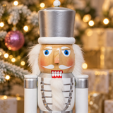50cm white and silver nutcracker soldier beside a Christmas tree