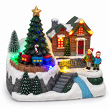Close-up of snowy Christmas village with train, house and illuminated tree