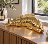 Gold ceramic koi fish ornament displayed on a sideboard