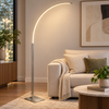 Febland LB50S 150cm satin nickel curved LED floor lamp glowing beside a sofa in a contemporary living room