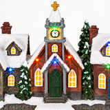 Close-up of LED Christmas village with houses church and snowy details