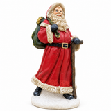 Pair of red Santa Christmas ornaments displayed beside a Christmas tree