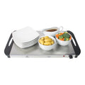 A plate with bowls containing potatoes, broccoli, carrots, and a white gravy boat with brown sauce, all arranged on a food warmer.