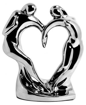 A silver sculpture of two people holding a heart, showcasing artistic craftsmanship and still life representation.