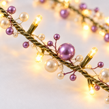 Close-up of warm white LED lights with lilac and white pearl beads