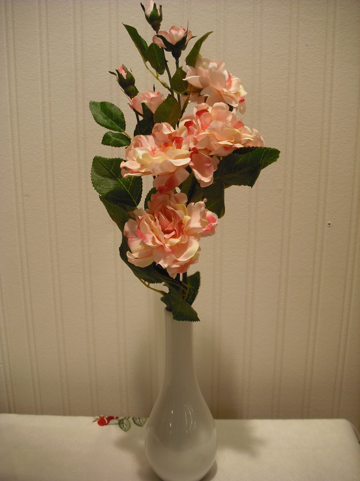 White artificial camellia flower arrangement in vase