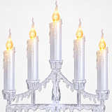 White five-candle LED Christmas candelabra in a festive window display