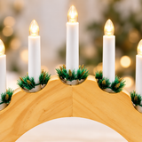 Close-up of warm white LED candles and pine detail on wooden Christmas candle bridge